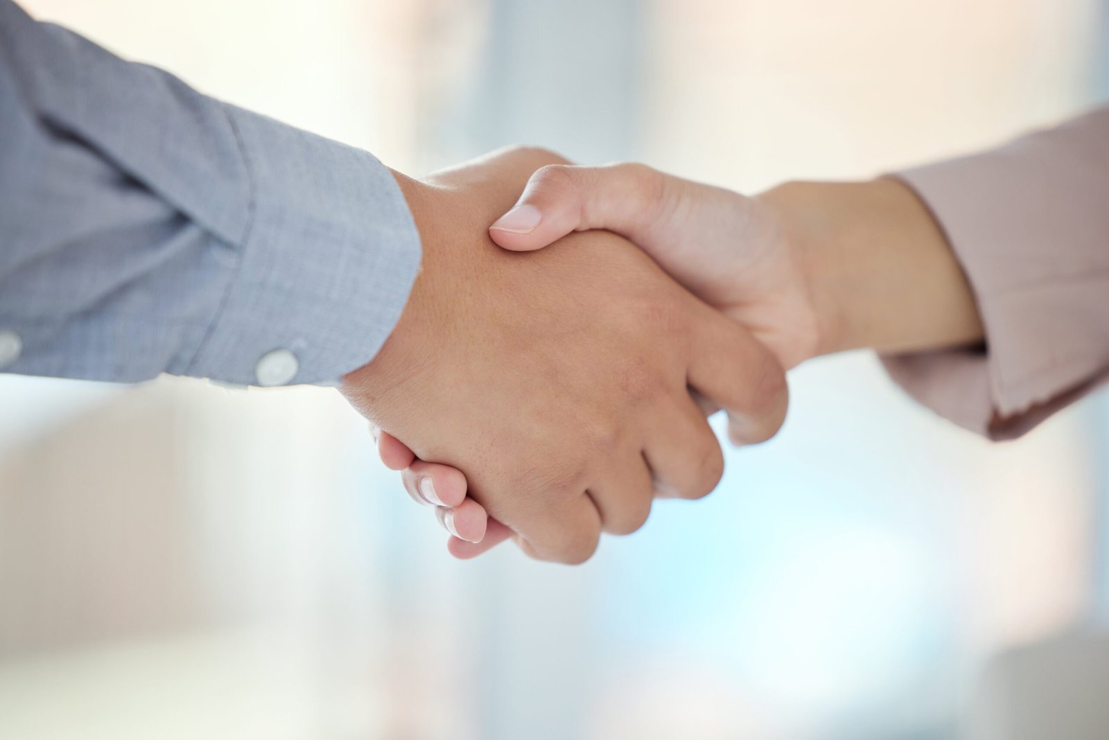 Closeup shot of two unrecognisable businesspeople shaking hands in an office.